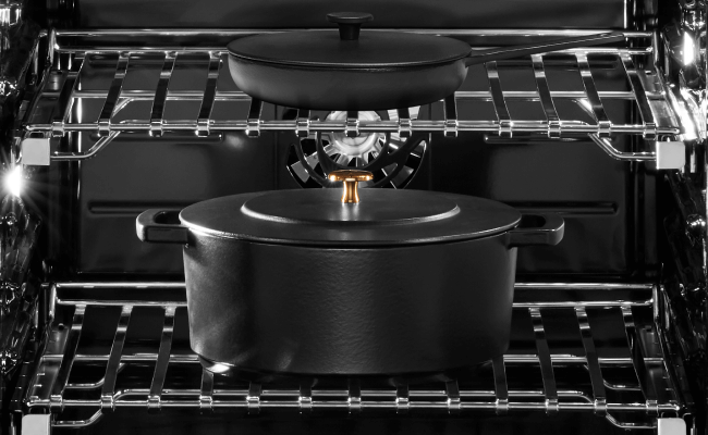  L'intérieur d’un four JennAir. Sur la grille du haut se trouve une petite casserole noire avec couvercle, et sur la grille du bas, une grande casserole noire avec son couvercle.