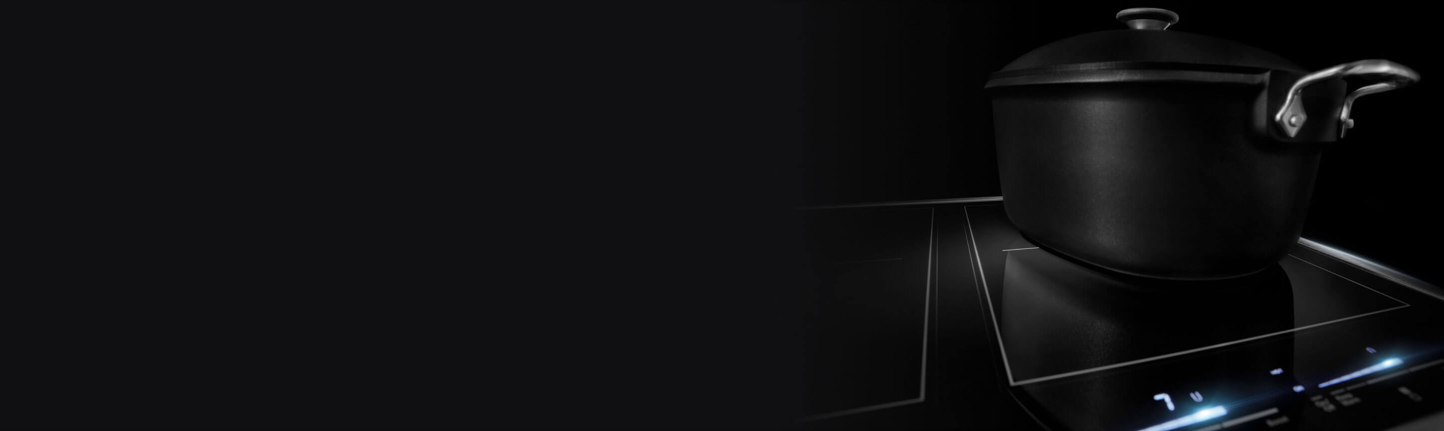 The burner of an induction stovetop with a black pot on it.