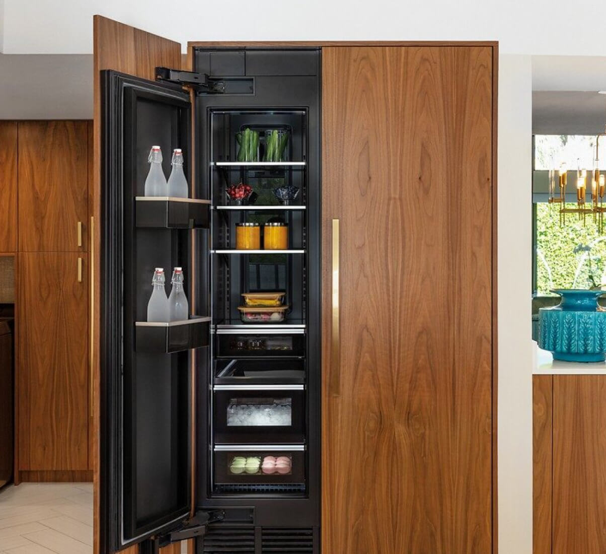 A midcentury modern kitchen featuring wood paneled JennAir® Column Refrigeration. A midcentury modern kitchen featuring wood paneled JennAir® Column Refrigeration.