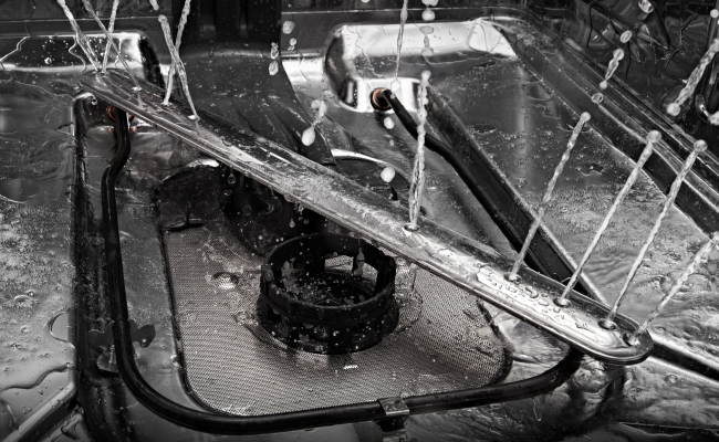 L'intérieur d’un lave-vaisselle JennAir en fonctionnement. Les jets projettent de l’eau.