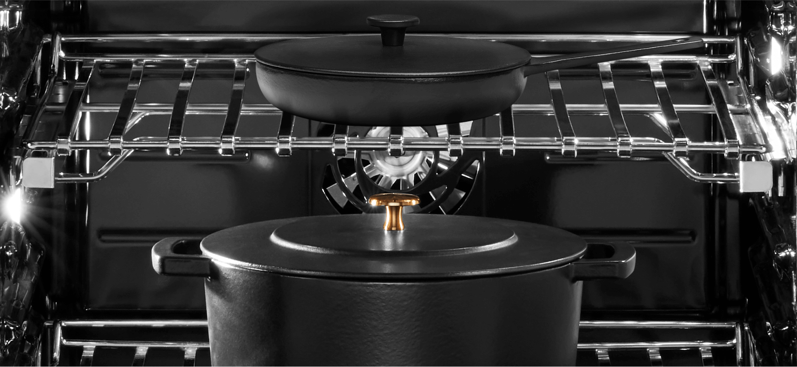  L'intérieur d’un four JennAir. Sur la grille du haut se trouve une petite casserole noire avec couvercle, et sur la grille du bas, une grande casserole noire avec son couvercle.