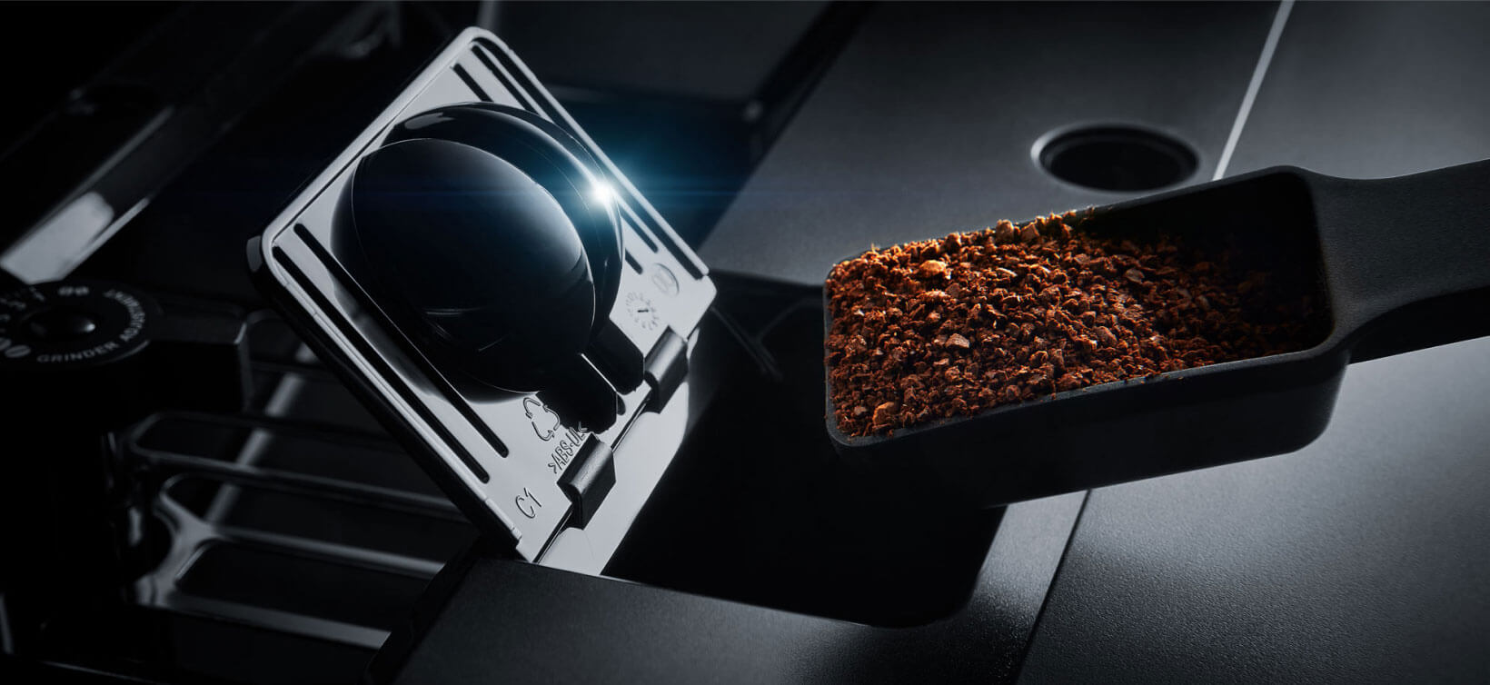 Une cuillère remplie de mouture de café au-dessus du compartiment ouvert d'une cafetière  Une cuillère remplie de mouture de café au-dessus du compartiment ouvert d'une cafetière