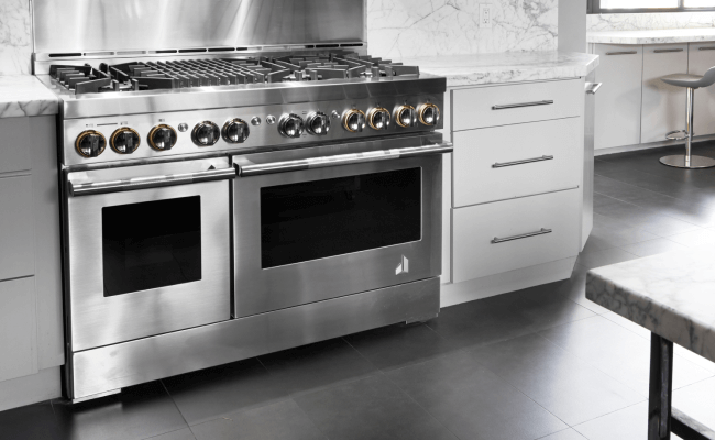 A high-end kitchen with JennAir double oven. Nearby are stools. 