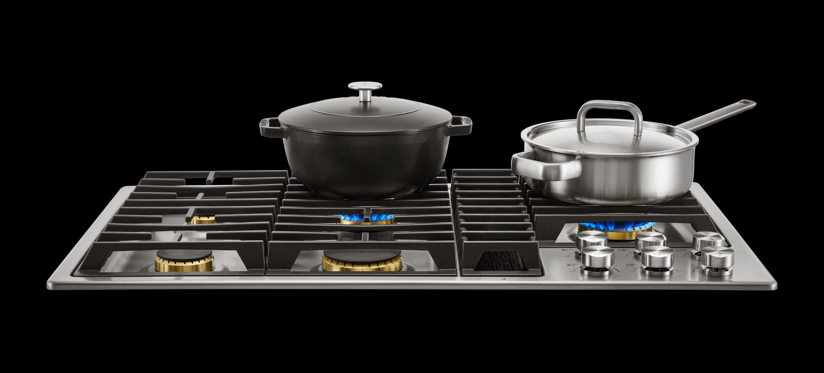 Variety of cooking pots on a downdraft cooktop, showcasing versatility.