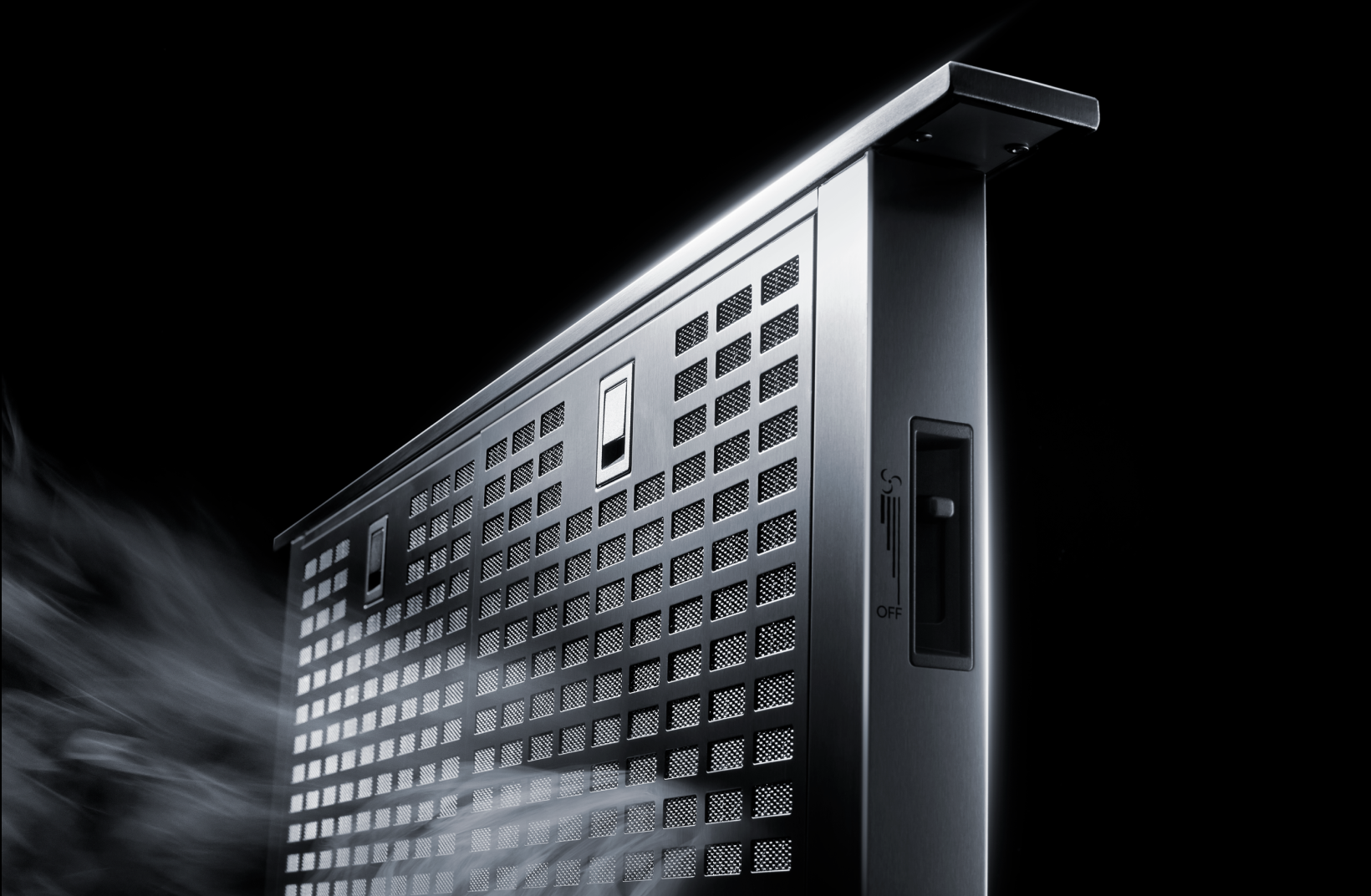 Close-up view of the downdraft ventilation slots on a cooktop, showing how smoke is pulled away from the cooking surface. Close-up view of the downdraft ventilation slots on a cooktop, showing how smoke is pulled away from the cooking surface.