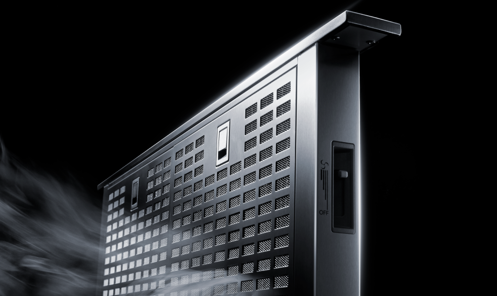 Close-up view of the downdraft ventilation slots on a cooktop, showing how smoke is pulled away from the cooking surface. Close-up view of the downdraft ventilation slots on a cooktop, showing how smoke is pulled away from the cooking surface.