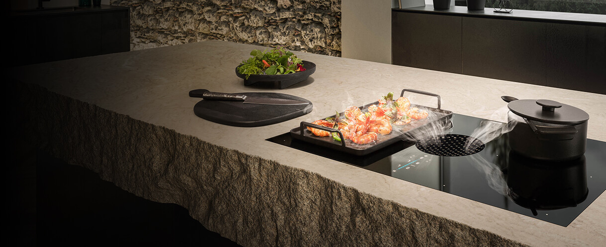 Une table de cuisson à induction à évacuation descendante dans une cuisine de luxe.