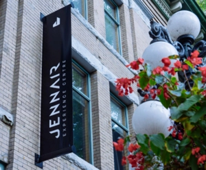 Outside the venue, a vertical JennAir banner hangs near a lamppost covered in flowers.