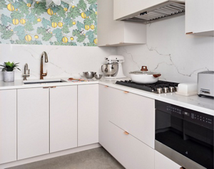 A kitchen with lemon tree wallpaper, a KitchenAid Stand Mixer, a lidded pan on a JennAir Cooktop and a JennAir Range.