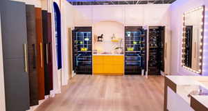 The JennAir Boutique with samples of refrigerator doors, refrigerators with glass doors, shelves of household items, and a beverage centre. There's also a vanity mirror on the wall.