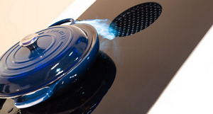 A blue lidded pan on an induction cooktop.