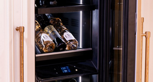 A JennAir beverage centre with three bottles on a shelf.