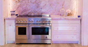 Part of the JennAir Boutique with a JennAir range with induction cooktop. On the counter are marketing materials and vases with flowers.