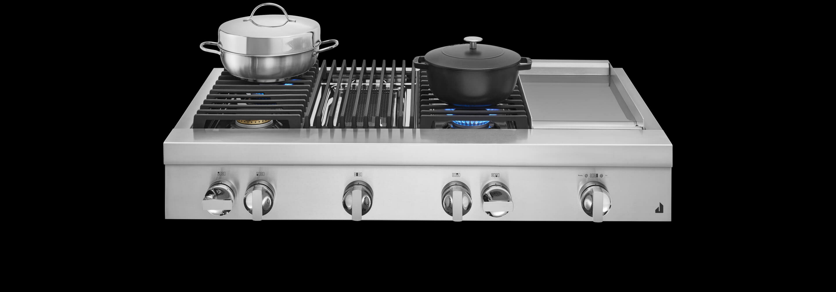 Une cuisinière JennAir® de style professionnel de design NOIR™, avec des casseroles en acier inoxydable et en fonte sur des brûleurs allumés.