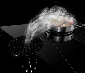 De la vapeur qui se dirige vers les évents d’une table de cuisson à induction avec hotte intégrée JennAir®.