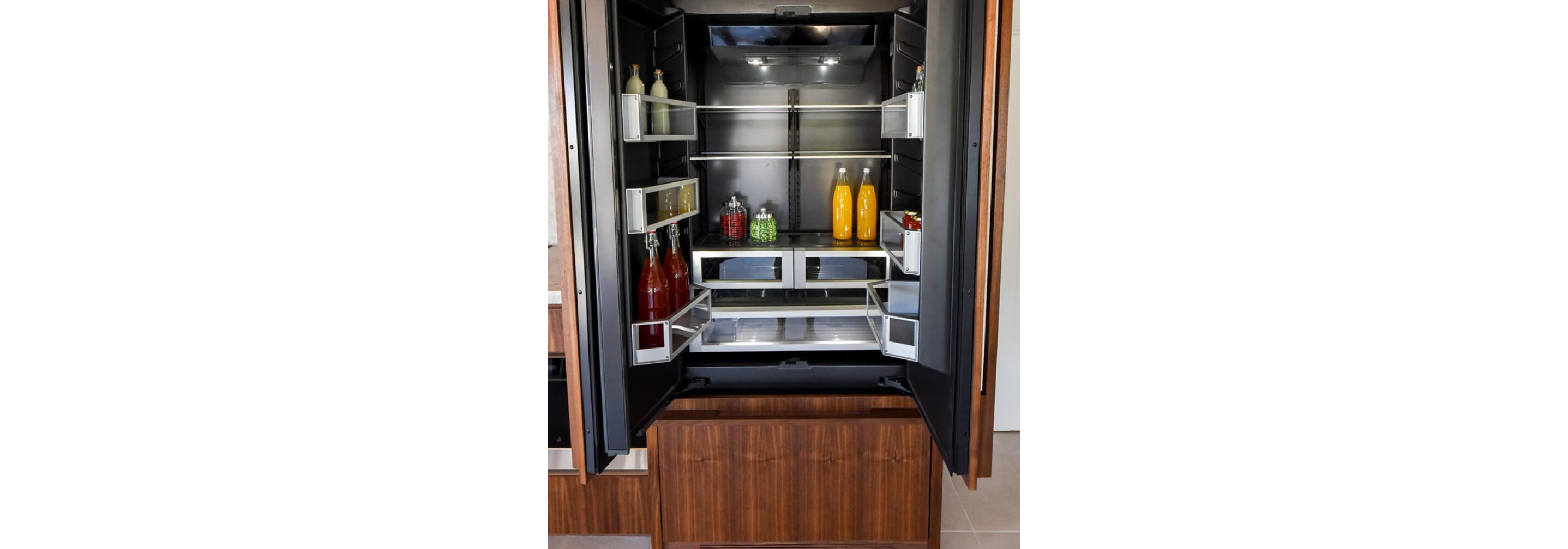 The lit Obsidian interior of a JennAir® Built-In Refrigerator.