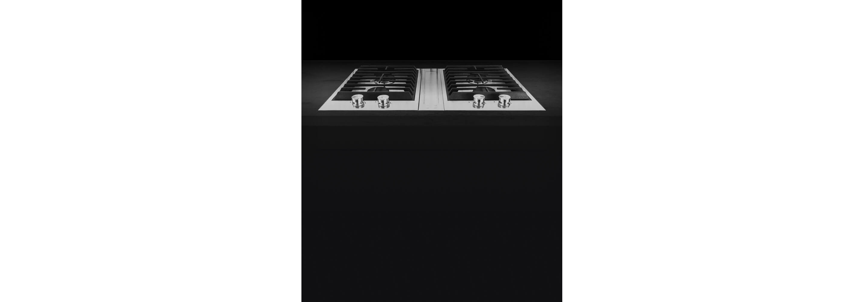 The downdraft vent between two 2-burner gas custom cooktops.