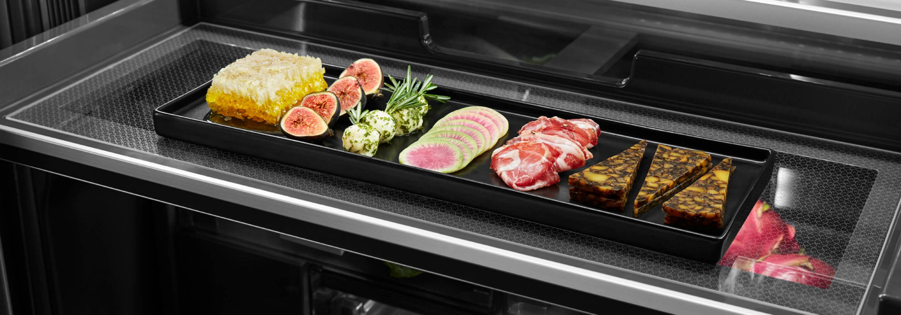 A charcuterie board with fruits, vegetables, meat and cheese inside the Gourmet™ Bay Drawer