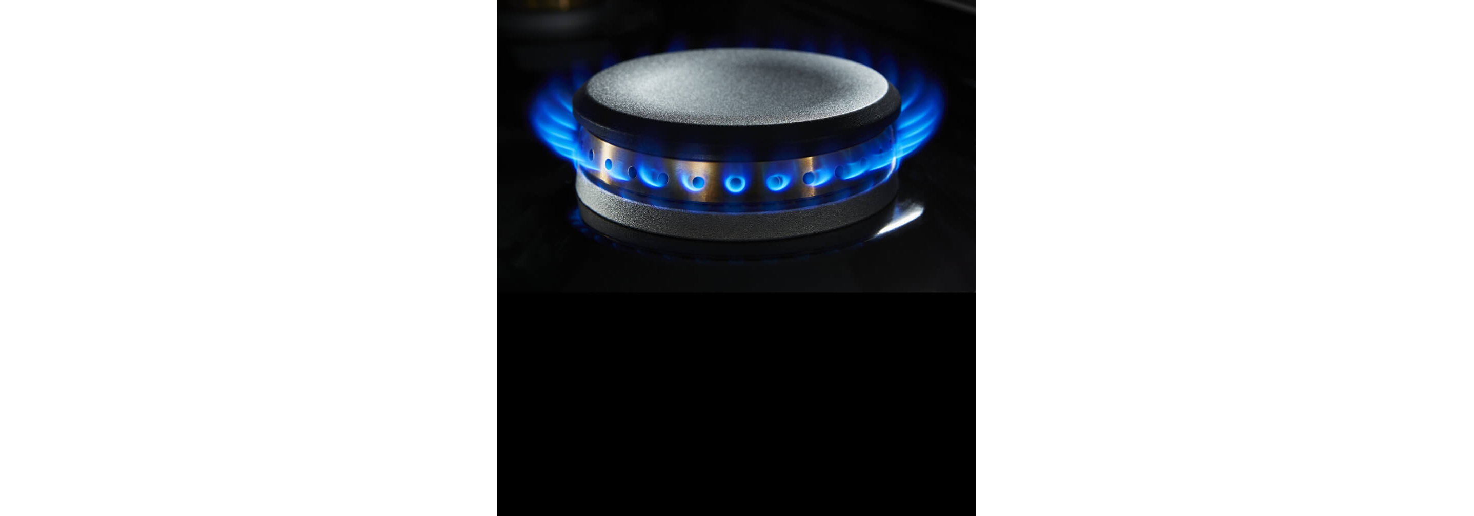 A lit dual-stacked burner on a gas rangetop.
