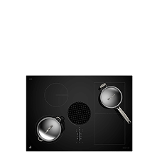 A downdraft induction cooktop with stainless steel pans on top.