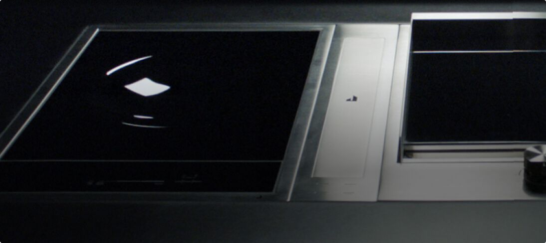 A closeup of a JennAir® 15-inch Chrome-Infused Griddle, 2-burner gas cooktop and a 4-inch downdraft ventilation strip, all part of the JennAir® Custom Cooktop lineup.